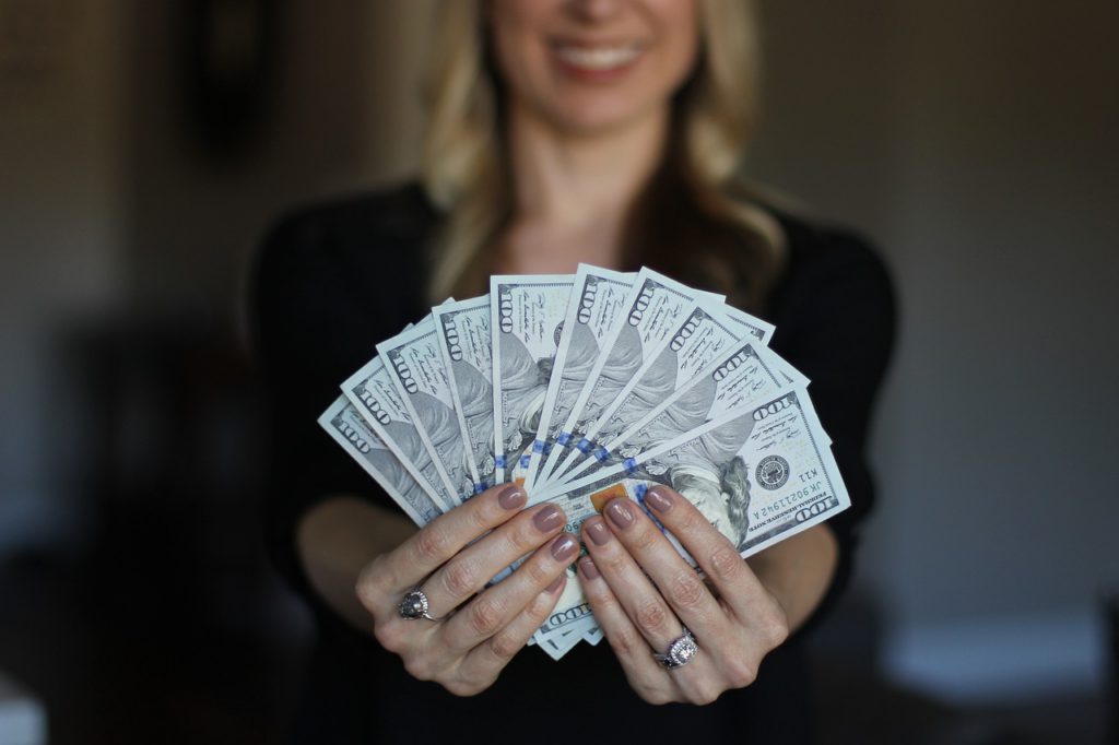 woman holding money using the loa