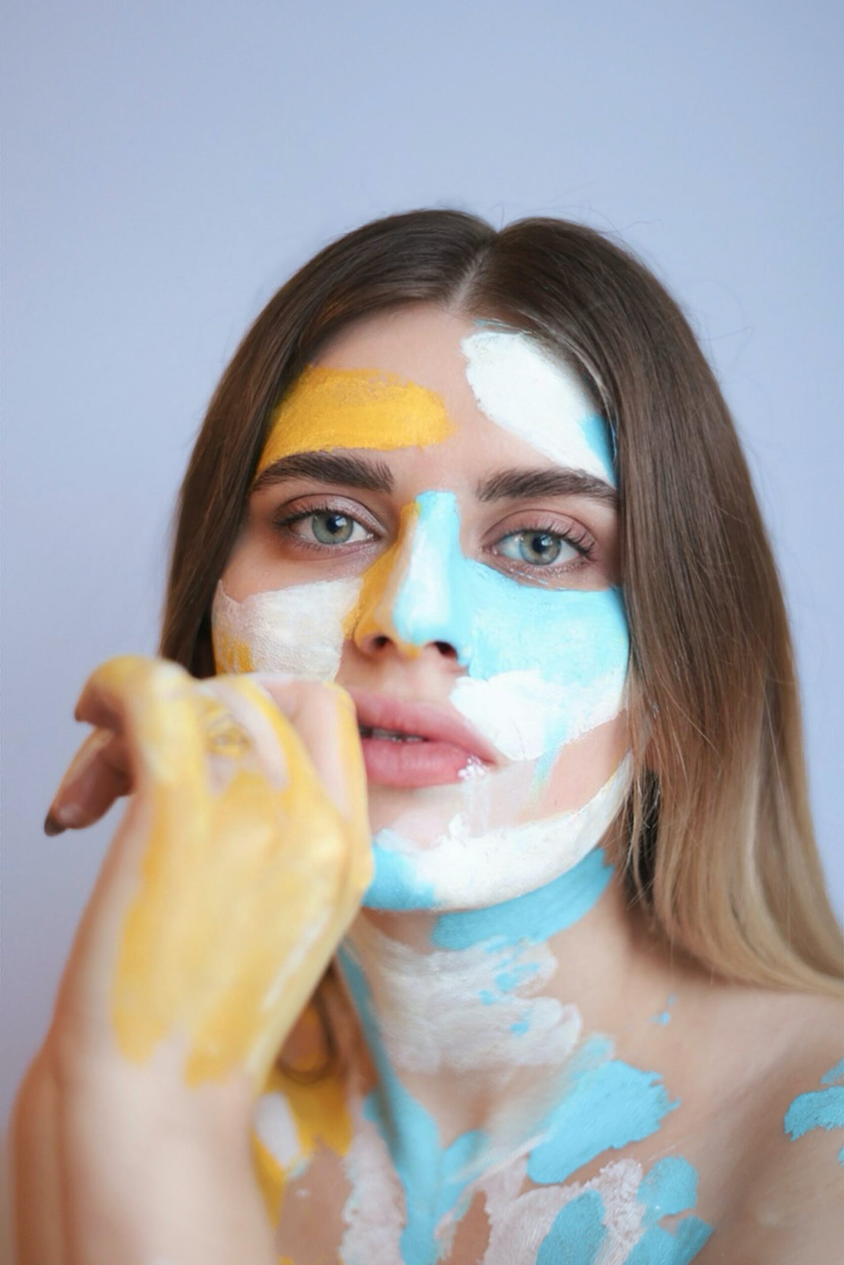 woman with blue and yellow paint on her face -true self with creativity